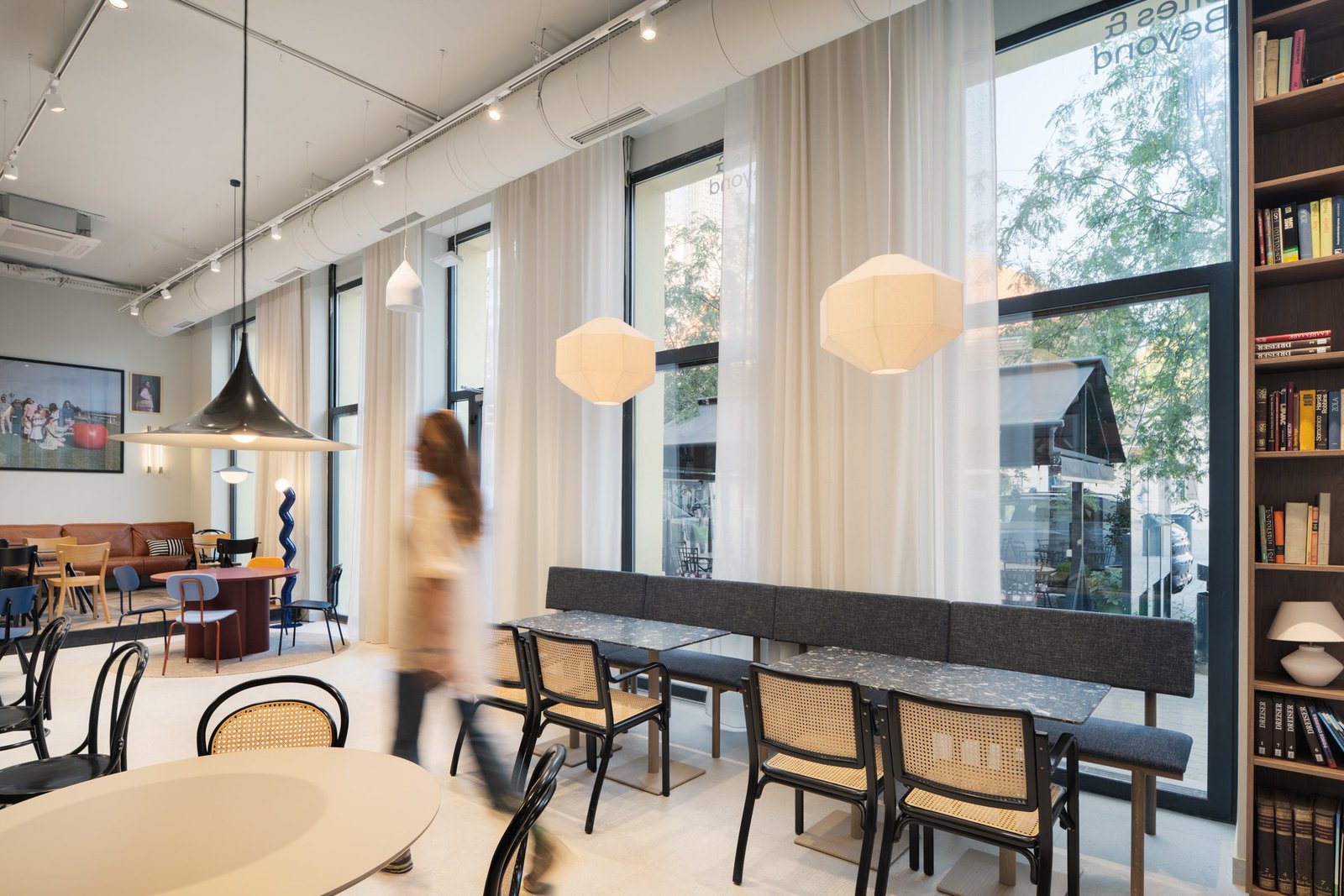 Bites and Beyond: dining room with tall windows, cane chairs and bookshelves