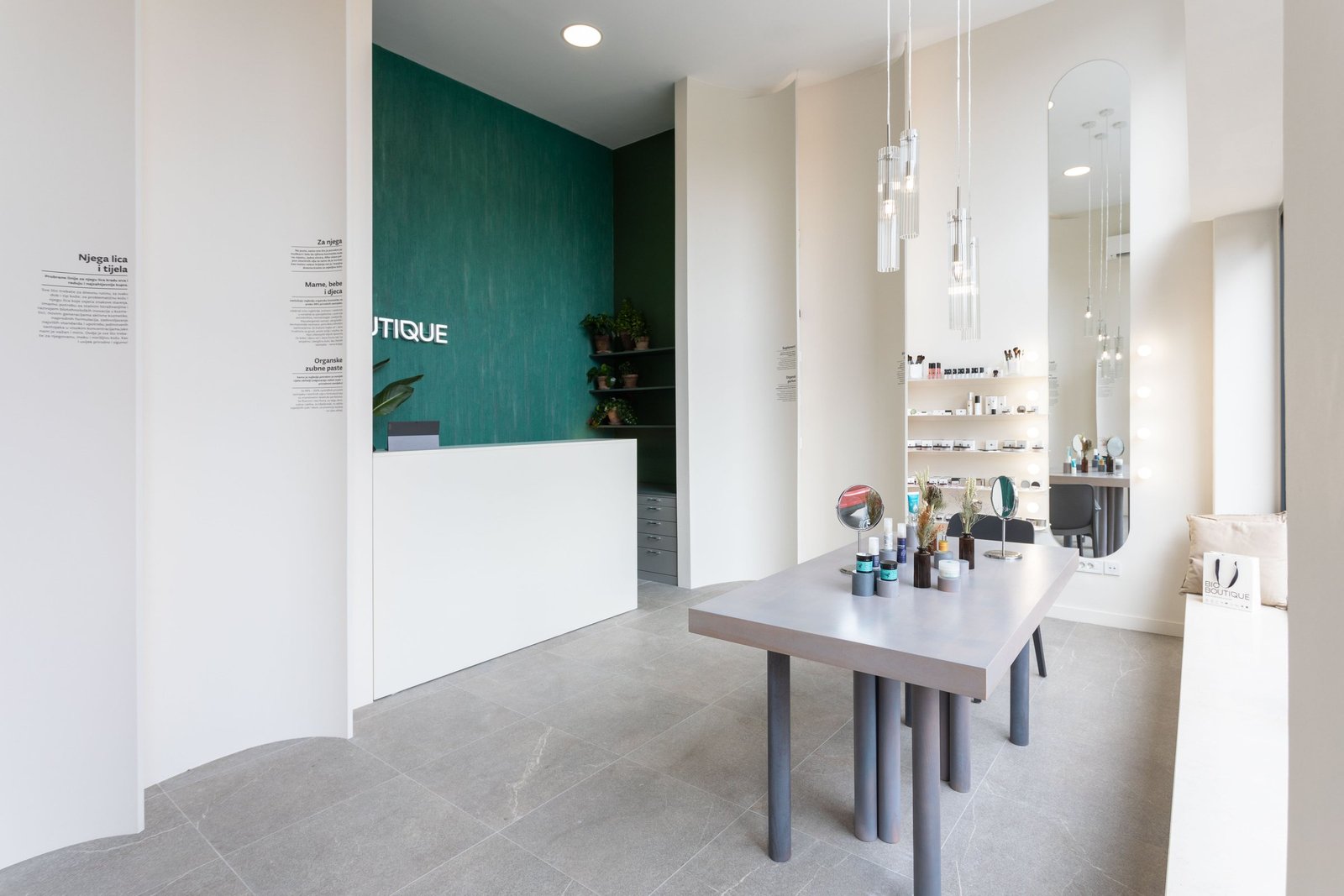 Bio Boutique: white curved shelving and a green wall